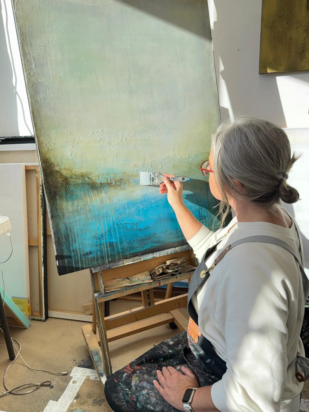 Ancient Waters, 30 x 40 abstract cenote painting shown in a sunny art studio with artist Jen Muse.