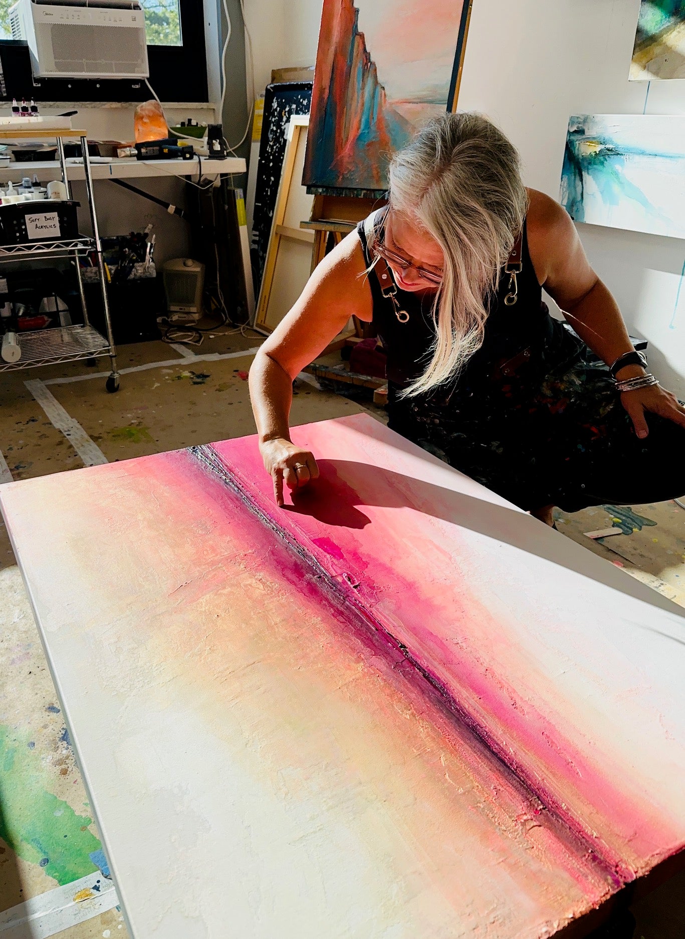 Artist Jen Muse working on Le Soleil Levant abstract painting in her studio