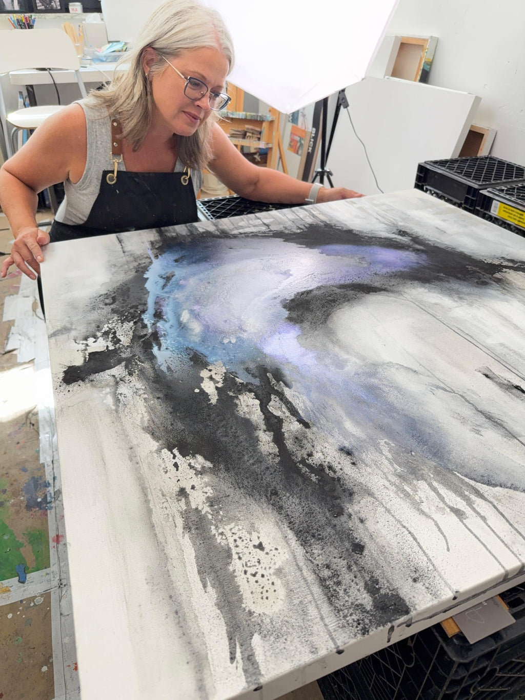 Artist Jen Muse with Coming Undone charcoal abstract painting in studio