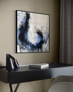 Enduring charcoal abstract painting in black floating frame over modern desk in office