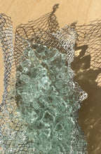 Detail of kiln-formed recycled glass and wire mesh texture in wall sculpture by Jen Muse