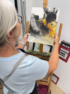 abstract charcoal painting shown with artist Jen Muse in her studio