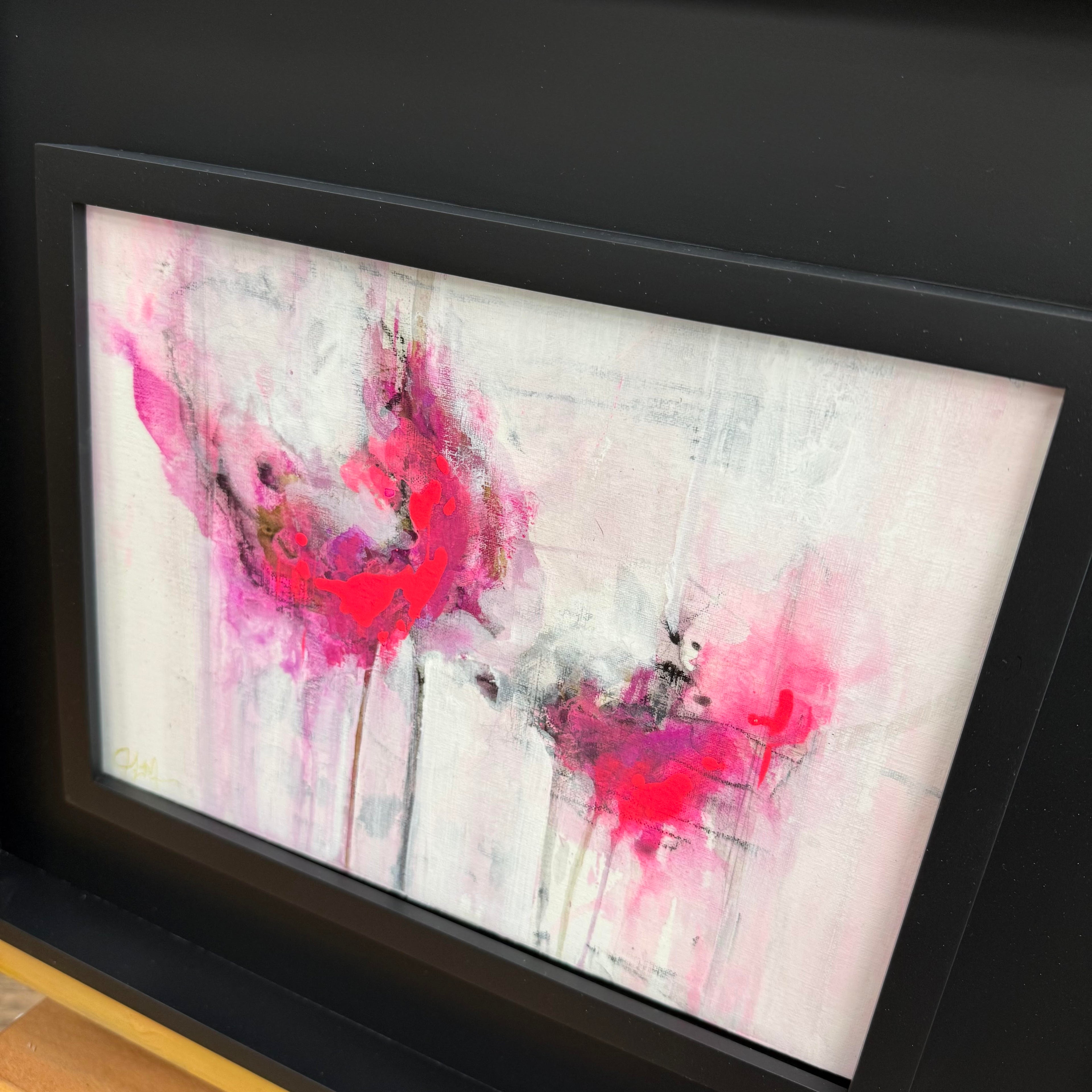 pink evanescence mini abstract study  with pink and red splashes framed in wide black modern frame